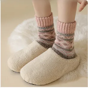 Winter fluffy slippers with vintage pink patterned socks on a soft white cozy carpet