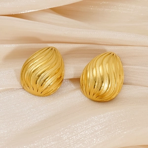 18K gold-plated stainless steel teardrop earrings with spiral texture on beige fabric