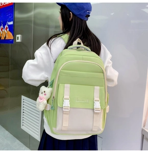 Nahaufnahme des grün-weißen Rucksacks mit Bärenanhänger und Details zum Stauraumdesign