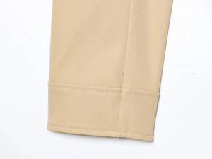 Close-up of khaki twill cotton fabric detailing double stitching on cuffs and hemline