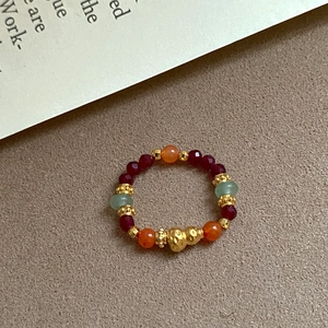Detailed shot of a vintage beaded ring with agate beads and a gold gourd pendant