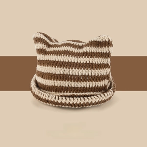Detail of cute striped knit beanie with devil ears and thick textured coffee-beige wool