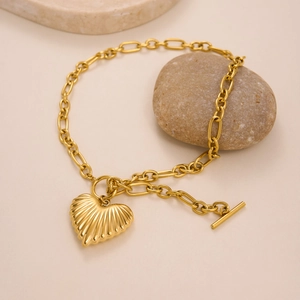 18k gold plated OT toggle necklace with textured heart pendant on a stone background