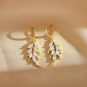 Elegant gold leaf hoop earrings with marquise white zircon crystals on champagne satin