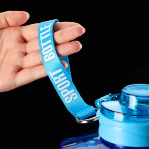 Close-up of blue sports bottle with durable woven carrying strap and clear lid