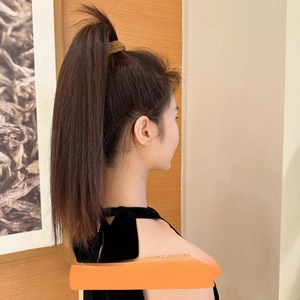 Detail of high ponytail hair extension piece showing smooth synthetic hair texture