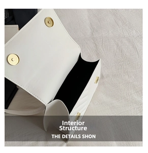 Detail view of white square bag featuring dual magnetic snaps and black inner lining