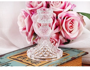 Macro detail of Nordic glass candle holder with diamond-cut texture on vintage book