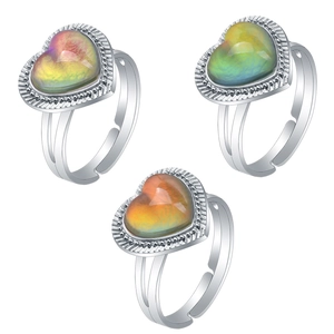 Detailed view of three heart-shaped mood rings in silver settings showing color transitions