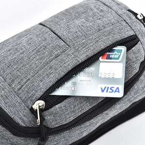 Detail of hidden zipper pocket for cards on a grey textured crossbody sports bag