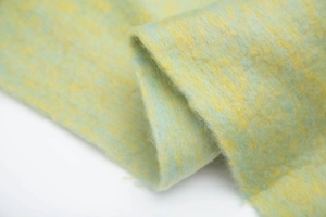 Close-up of textured boucle knit scarf in light green and yellow mixed yarn