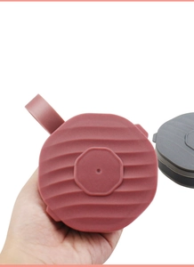 Dettaglio dei coperchi in silicone rosso-marrone e grigio con motivo a onde per tazze pieghevoli