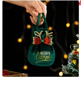 Detail of green velvet Christmas gift bag with gold antlers and sequin bow accent