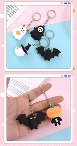 Detail of Halloween PVC keychains showing pumpkin and ghost designs held in hand