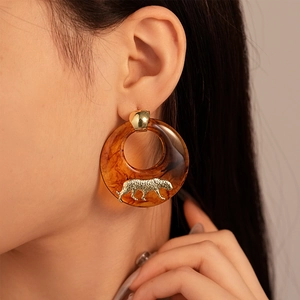 Maillard resin hoop earrings with amber leopard accents on a model's profile