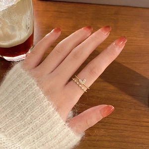 Close-up of elegant double-layered gold ring with pink heart zircon on hand