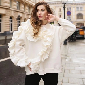 Détail d'un sweat-shirt blanc à manches longues avec volants et texture en coton épais