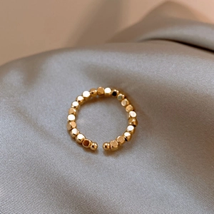 Vista macro dell'anello aperto con perline placcato oro 14k su seta argentata