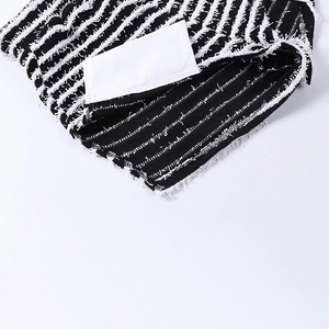 Détail macro du tissu en maille rayé noir et blanc avec franges et doublure intérieure