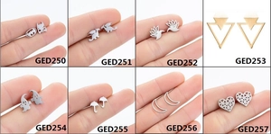 Detailed close-up of various stainless steel animal and logo stud earrings set