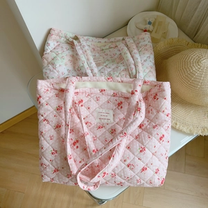 Close-up of pink and green floral quilted cotton tote bags with diamond stitching details