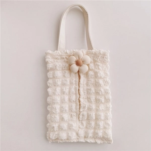 Close-up of cream floral bubble textured tissue holder for car seat headrest