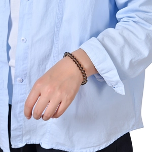Detailed close-up of 8mm dark brown crystal beaded bracelet worn on a female wrist