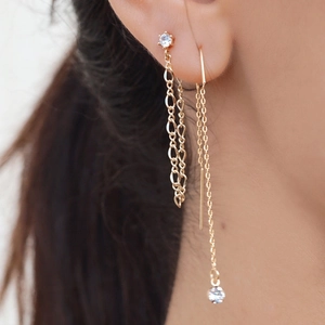 Close-up of gold tassel star earrings on model showing elegant dangling chain detail