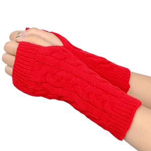 Detailed knit texture of red cable-knit fingerless gloves made of warm acrylic yarn