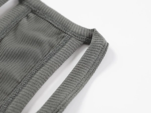 Macro shot of grey ribbed knit fabric showing detailed texture and stitching of the tank top