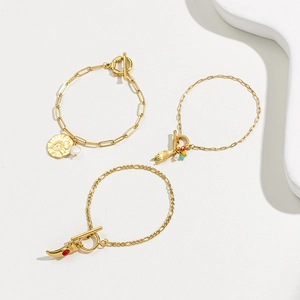 Three gold stainless steel toggle bracelets with red turquoise and horn heart pendants