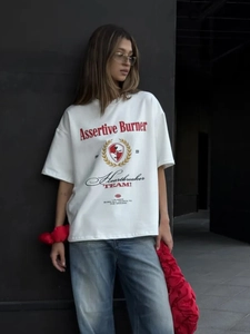 Λεπτομέρεια από λευκό βαμβακερό oversized T-shirt με έντονα κόκκινα και μαύρα σχέδια