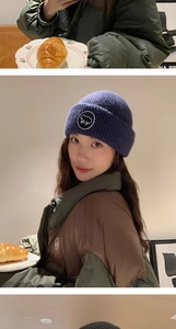 Détail d'un bonnet en maille bleu marine avec broderie et veste d'hiver sur un mannequin