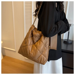 Dettaglio della borsa shopper trapuntata color caramello con catena d'oro e mini borsa
