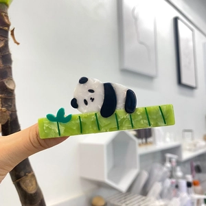 Detail of green acetate hair claw clip featuring cute 3D panda bear animal patterns