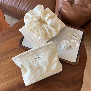 Detailed cream pleated pouch with textured dot fabric, matching scrunchie and lace hair clips