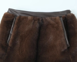 Detail view of brown faux fur and dark brown leather patchwork stitching on skirt