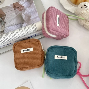 Detail view of corduroy cosmetic bags with zipper closure and colorful woven handles