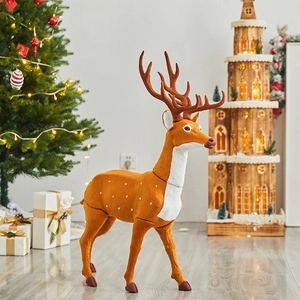 Realistic Christmas reindeer decoration with spotted fur standing by a festive holiday tree