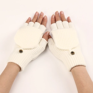 Detail view of cream white knitted fingerless gloves with a flip top and brown button