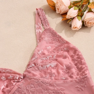 Gros plan du haut caraco en velours rose avec tulle floral et décoration de roses