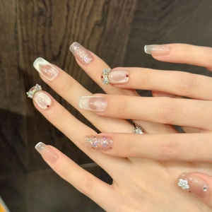 Detailed view of press-on nails with cat eye finish, sequins, and 3D bow decoration