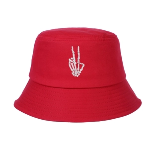Dettaglio del ricamo a mano di scheletro bianco su un cappello a secchiello rosso