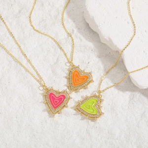 Macro detail of colorful enamel heart pendants with shiny zircon studs on gold chains