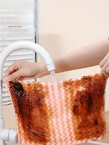 Detail of pink and white coral velvet cloth being rinsed under water to remove oil stains