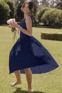 Detailed view of dark blue maxi dress fabric with elegant flared hem in a sunny garden