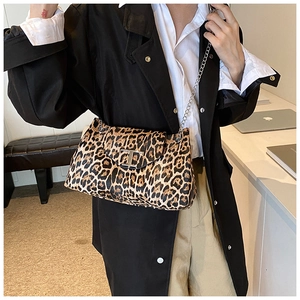Close-up of leopard print bag with silver chain strap and signature T-shaped metal buckle
