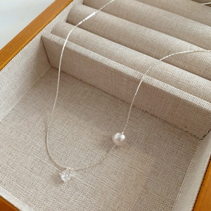 Gros plan détaillé d'un collier avec perle et zircon dans un coffret à bijoux en bois chic
