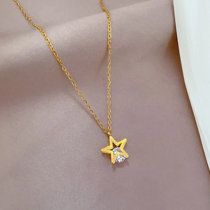 Macro detail of gold star pendant with sparkling clear zircon stone on a fine chain