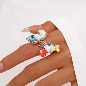 Detail view of colorful dopamine shell rings with heart and floral motifs on a hand